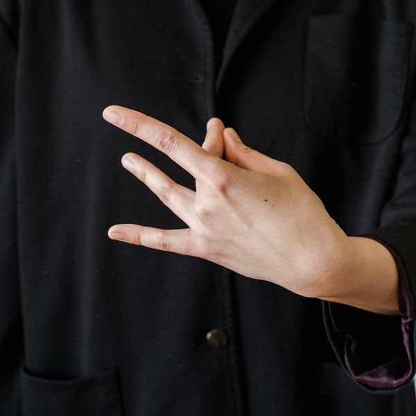 Close-up of a person's hands in a meditative mudra gesture.